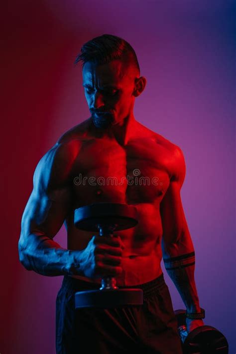Bodybuilder is Doing Bicep Hammer Curls with Dumbbells Under Blue and Red Lights Stock Image ...