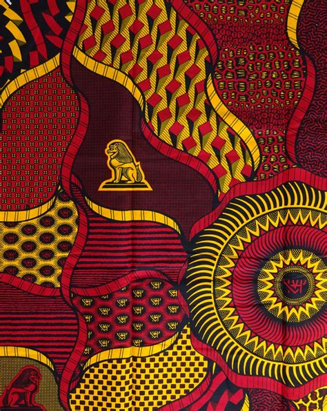 an african print fabric with red, yellow and green designs on the bottom half of it