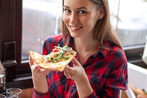 Premium Photo | Young girl eating a slice of pizza indoors girl student ...