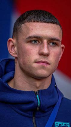 a close up of a young man wearing a blue hoodie and looking at the camera