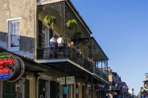 People Standing on a Balcony Having Drinks on Bourbon Street with Restaurants and Bars Along the ...