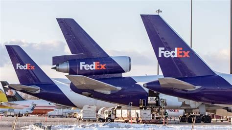 three fedex airplanes are parked on the tarmac at an airport in the snow