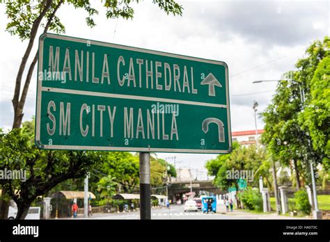 Manila Cathedral sign. Road sign in Manila directing traffic to Manila Cathedral and SM City ...