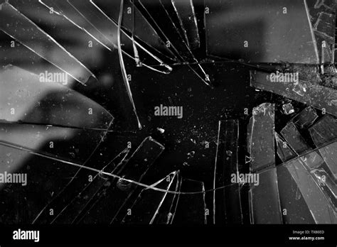 Broken glass texture background in black and white with many pieces and shattered parts. Styled ...