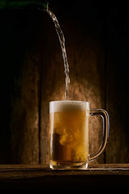 Premium Photo | Pouring beer into the glass