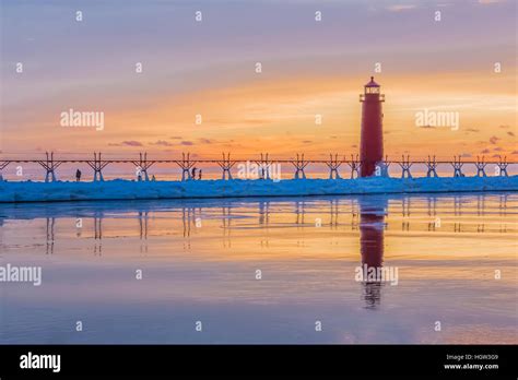 Grand Haven Lighthouse at sunset, at the mouth of the Grand River where ...