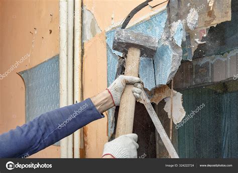 The builder hammer breaks old partitions in the apartment Stock Photo ...