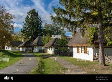 Historical old hungarian village with straw roof houses and a bench ...