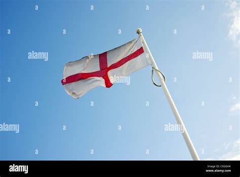 England flag blowing in the wind blue sky Stock Photo - Alamy