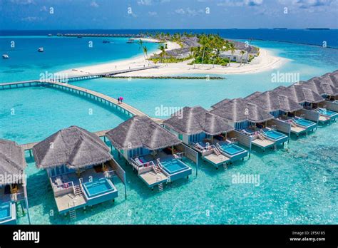 Aerial view of Maldives island, luxury water villas resort and wooden ...