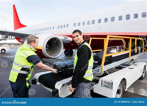 Worker Smiling while Colleague Unloading Luggage on Runway Stock Photo - Image of occupation ...