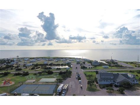 an aerial view of the ocean with houses and cars parked on the road ...