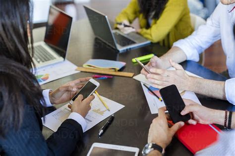 Business people using cell phones during a meeting in office stock photo