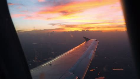 Beautiful sunset over the city, view from the airplane window. Airplane sunrise flight ...