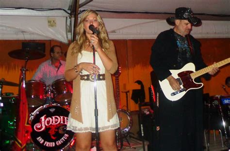 a man and woman singing into microphones while standing next to each other on stage