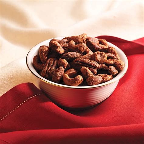 a bowl filled with nuts sitting on top of a red cloth next to a napkin