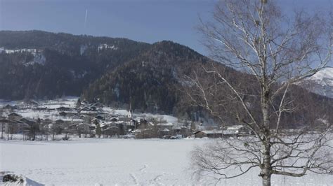 a snowy field with a small village in the background 32509801 Stock Video at Vecteezy