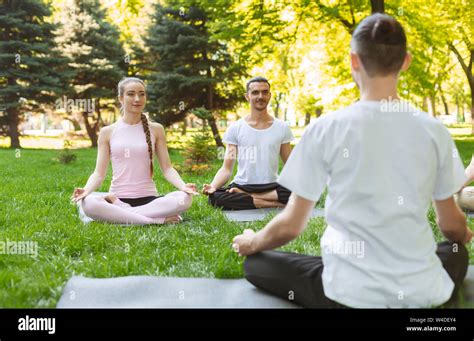 Yoga teacher and beginners in outdoor class, making easy postures Stock Photo - Alamy