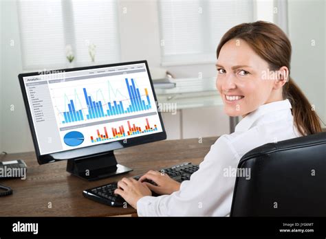 Young Happy Businesswoman Analyzing Graph On Computer At Wooden Desk Stock Photo - Alamy