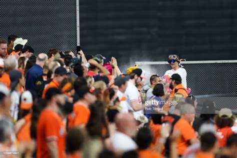 Baltimore Orioles fans are sprayed with a hose by 'Mr. Splash' during ...