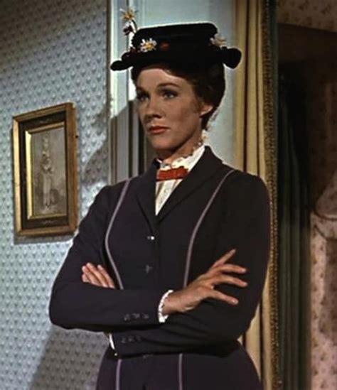 the woman is standing with her arms crossed wearing a hat and bow tie, looking at the camera