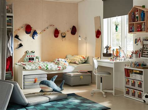 A contemporary children’s bedroom with wood clad walls and a blue rug and the SLÄKT bed frame ...