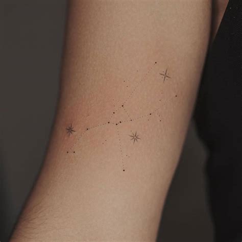 Minimalist Taurus constellation tattoo on the bicep.