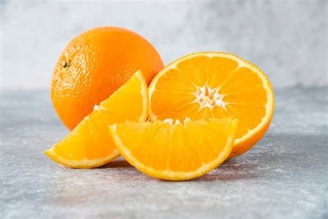 Free Photo | Sliced and whole juicy orange fruits on stone table