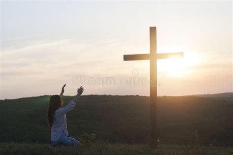 A Woman is Kneeling with Her Hands Up. Near the Cross. Prayer of Repentance. Christian Faith ...