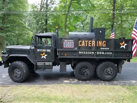 a large black truck parked on the side of a road next to an american flag