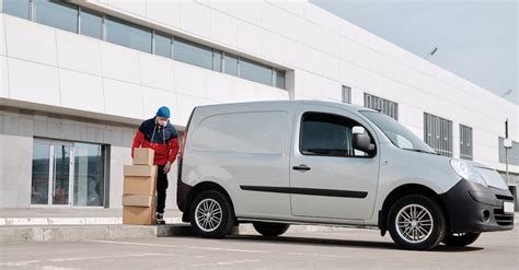 Delivery Man With Boxes next to a White Van · Free Stock Photo