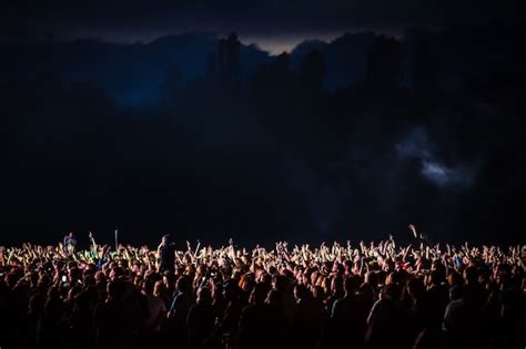 Premium Photo | Crowd of spectators at a concert at night lit by a spotlight from the stage