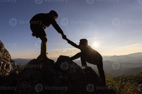 silueta de mano amiga entre dos escaladores. Pareja de senderismo se ayuda mutuamente a la ...