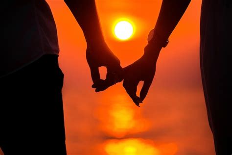 Premium Photo | Love - romantic couple holding hands, beach sunset ...