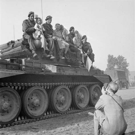 A Cromwell tank crew poses for photos with local children in Valkenswaard 18 September 1944 ...