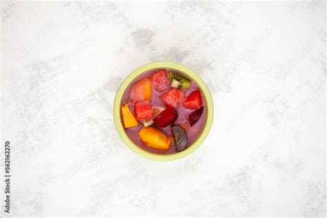 Sop Buah or Es Campur in green bowl on the table, top view. Es buah Indonesian popular fruit ice ...