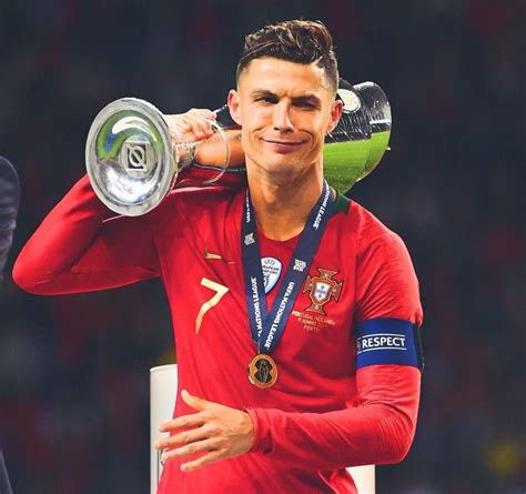 a man holding a silver trophy in his right hand and wearing a red shirt ...