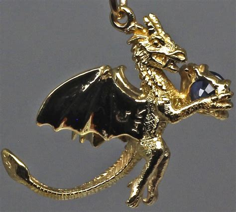 Sapphire dragon pendant 14K A small dragon sculpted out of yellow gold.
