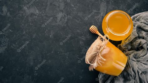 Premium Photo | Honey in a jar on a black stone background free space for text top view