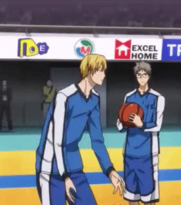 two men in blue uniforms standing next to each other on a basketball court, one holding a ball