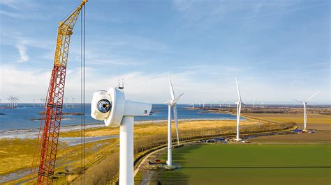 aerial-wind-farm-in-construction-crane-onshore-blue-sky-green-field ...