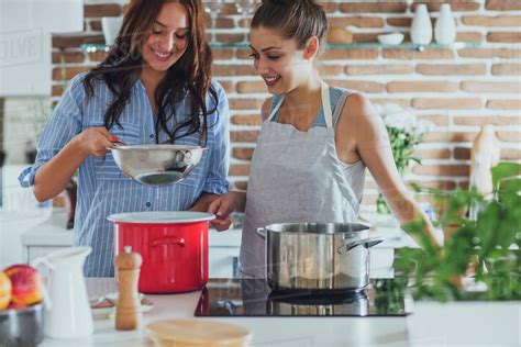 Caucasian women cooking in kitchen - Stock Photo - Dissolve