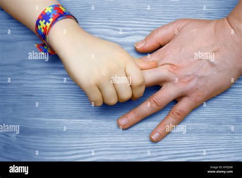 Autism Awareness Picture. Father holding hand her Autistic Child Stock Photo - Alamy