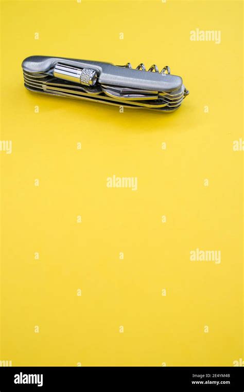 Vertical shot of a small folding pocket knife on a yellow surface under the lights Stock Photo ...