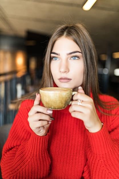 Free Photo | Portrait of young woman drinking coffee at table with ...