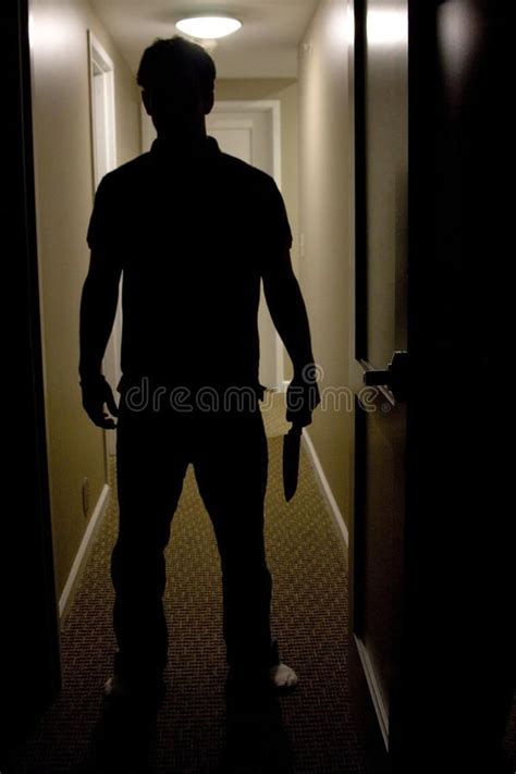 Man With Knife. A mans silhouette is shown coming into a dark room ...