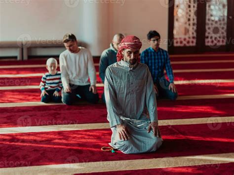 A group of Muslims in a modern mosque praying the Muslim prayer namaz ...