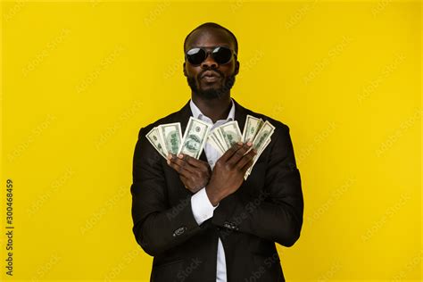 bearded luxury young afroamerican guy is holding lots of money in both ...