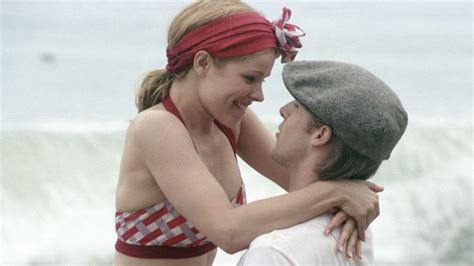 a woman in a red and white bathing suit hugging a man wearing a bandana