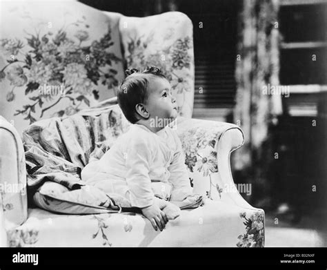 Baby sitting on armchair Stock Photo - Alamy